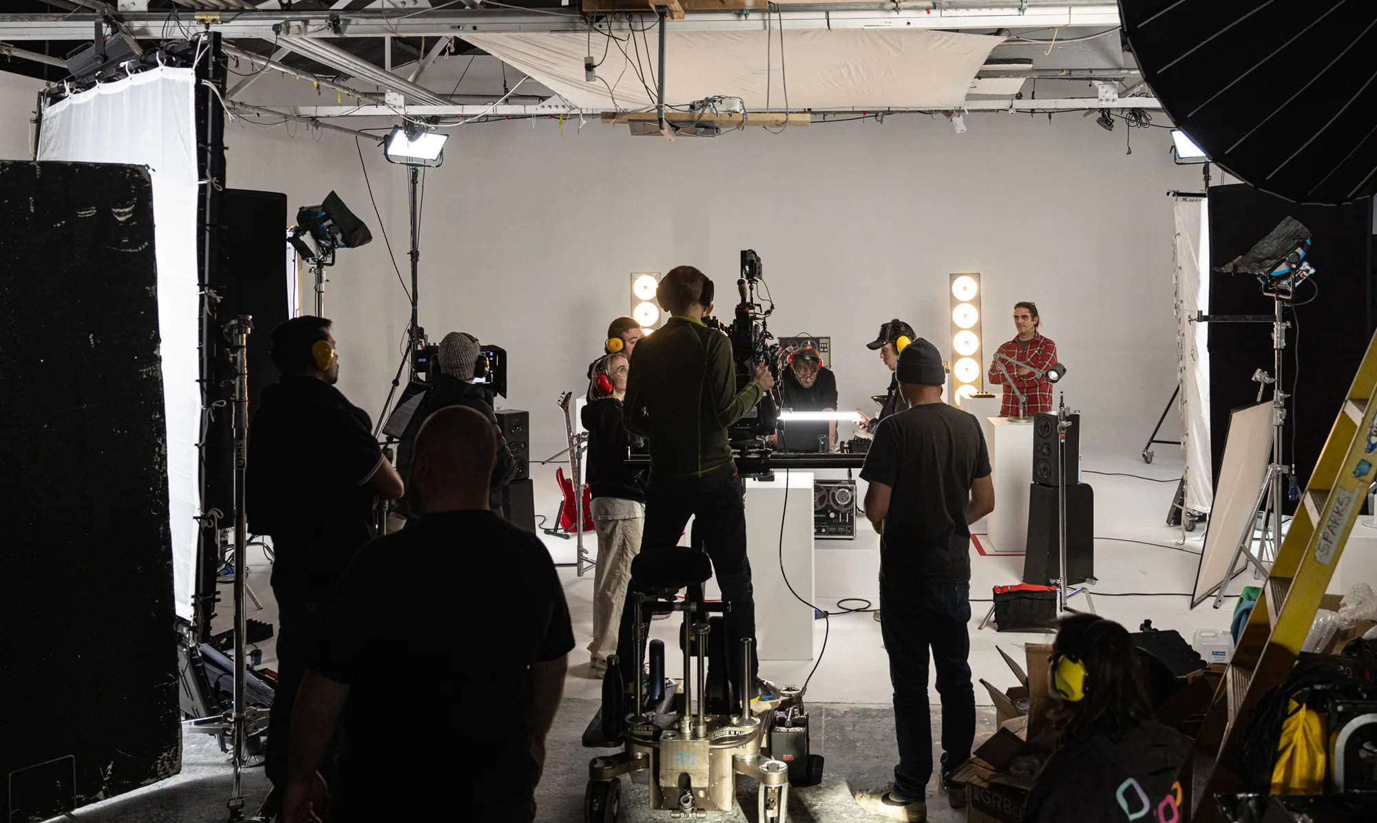 people standing in a studio production set. Our Team feature page